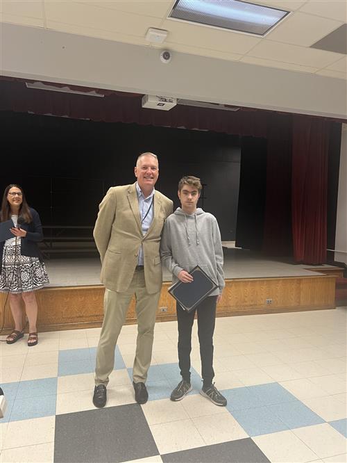 Adam L. poses with his Creekside Award and the District Superintendent.